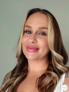 A smiling woman with long blonde hair and blue eyes.